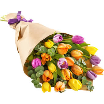 Bukett med färgglada tulpaner, invirade i presentpapper. Blommorna ingår i Euroflorists tulpansortiment.