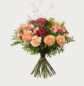 Höstbukett hos Interflora, med rosor, nejlikor, krysantemum och santini. Aprikosa, lila och gröna färgtoner.