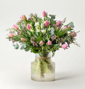 Bukett med rosa tulpaner, vaxblommor och blandat grönt. Beställ hos Interflora!